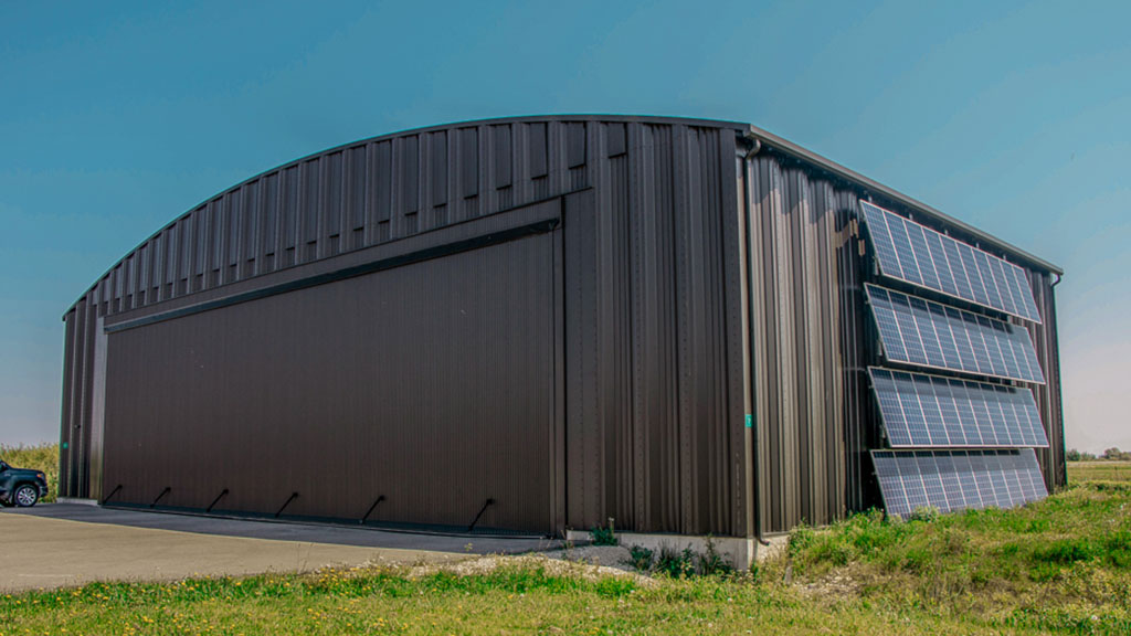 U-Build It's easy to plan for future expansion with Frameless Steel Buildings as they can be expanded in length at any time. This picture features an airplane hangar located at a small rural airport.